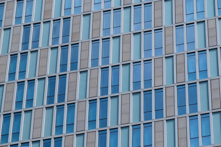 A detailed view of a building facade featuring a repetitive pattern of windows and panels.