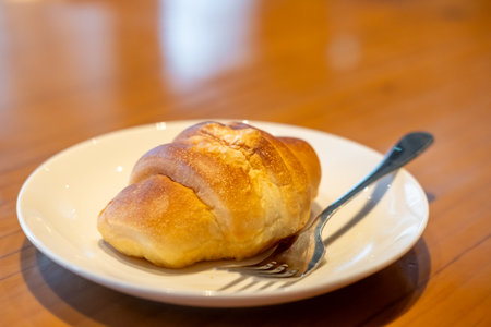 Salted bread served on plate with fork, on the wooden table