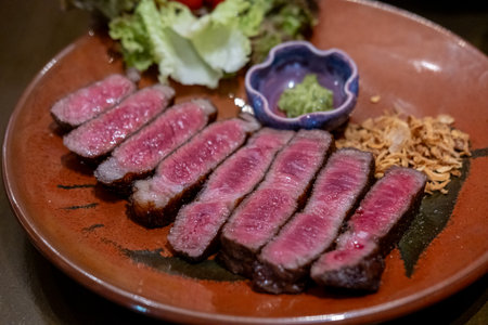 Medium rare sliced rib eye meat served on plate with vegetableの写真素材