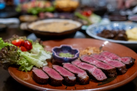Medium rare sliced rib eye meat served on plate with vegetableの写真素材