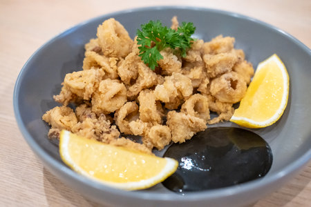 Close-up photo of Fried Squid or Calamari with lemon served on plate.の写真素材