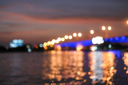 Blurred image bokeh of sunset sky with the bridge and riverside buildingの写真素材