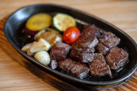 Diced meat steak served on plate with various vegetableの写真素材