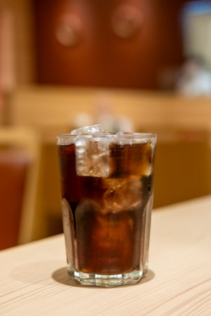 A glass of Cola on the table with bokeh background