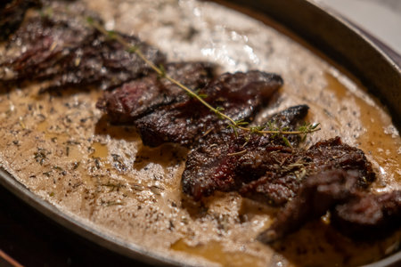 Medium rare grilled meat with gravy sauce on panの写真素材