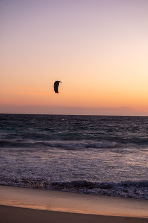 Sunset view of Scarborough Beach in Perth, Australia. with silhouette of a person kitesurfing or skysurfing, surf with a parachuteの写真素材