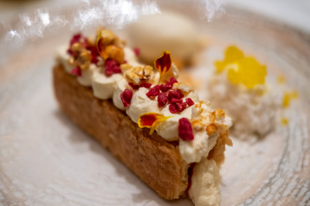 A tart with cream on top, with vanilla ice cream and crumble served on plate.の写真素材