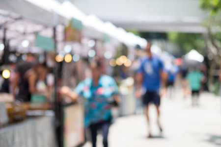 Blurred image of people walking around ourdoor marketの写真素材