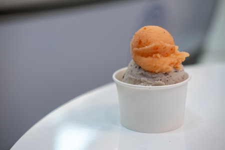 A cup of Gelato, Banana choc chip and tomato Ice-cream on the table with blur background.