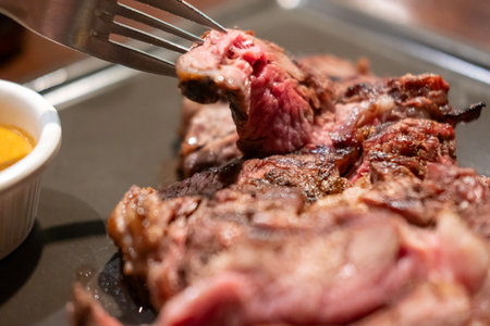 Medium rare rib eye angus steak on a fork