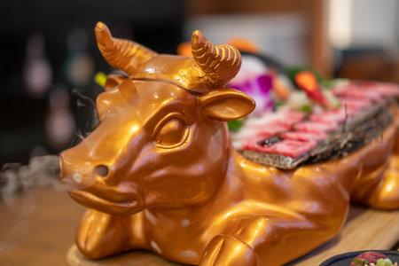 Golden cow shaped plate for Japanese style sliced wagyu beef.の写真素材