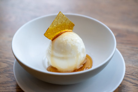 Honey ice cream with topping, served in a white bowlの写真素材