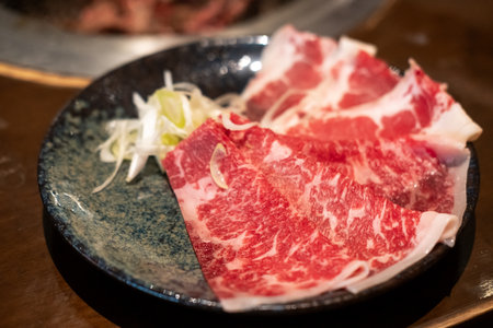 Sliced Negidare wagyu served on plate, a Wagyu beef with a soy based sauce made with green onions or scallionsの写真素材