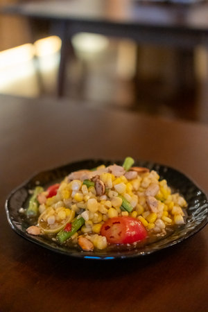 Spicy corn with salted egg salad, or Som Tum with corn, served on plate.の写真素材