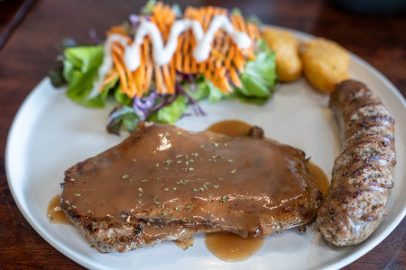 Set of grilled sausage with steak served on plateの写真素材