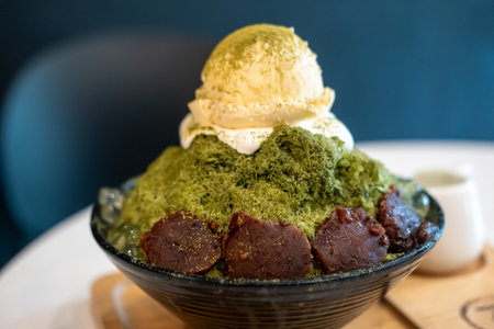 Green tea bingsu with red bean and ice cream on top, served in a bowl