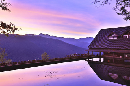 Beautiful scenery of lake with mountains and house in the dawnの写真素材