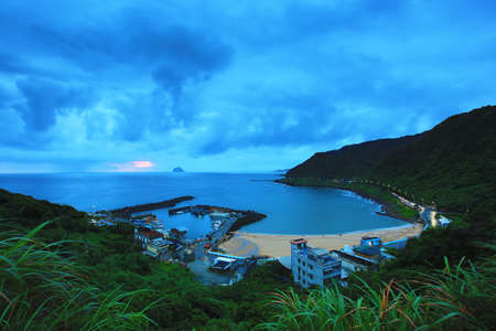 Dawn landscape with fishing port and beautiful bay surrounded by mountainsの写真素材