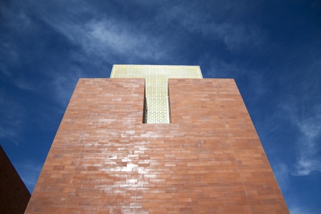 A brick tower with yellow glass and blue skyの写真素材