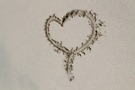 A heart drawn in the sand on a beachの写真素材