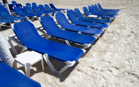 Rows of blue several lounge chairs on the beachの写真素材