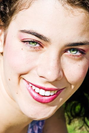 Close up on the face of a beautiful young woman smiling at the camera. Youth, happiness, joy, serenity concept.の写真素材
