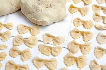 Raw handmade pasta in shape of bow tie over a white table cloth. Traditional italian cuisine.の写真素材