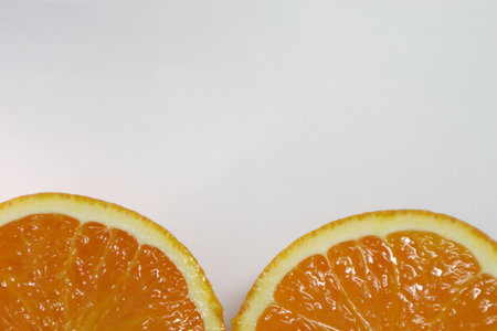 Two halves of orange on a white background with space for text.の写真素材