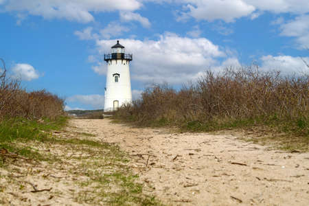 Lighthouse on a dune with a blue sky in the backgroundの写真素材