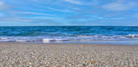 Beautiful seascape. Small waves of the sea on the sandy beach.