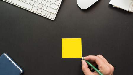 workspace desk with post it and hand copy space background  blackの写真素材