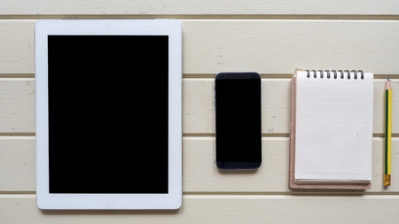 taplet and notebook with smart phone topview on wood backgroundの写真素材