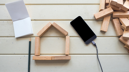 house  Symbol wooden block and smart phone with notebook and pencilの写真素材