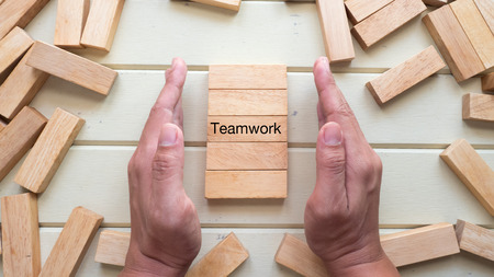 team work word written on wood block with hand top viewの写真素材