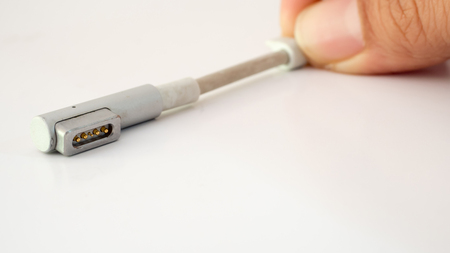 Charger plug laptop with hand close up white backgroundの写真素材