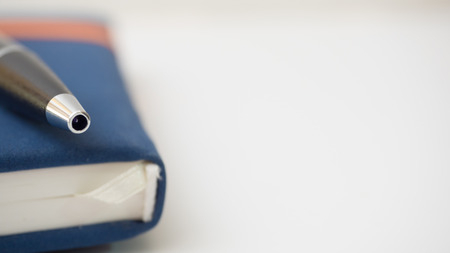 pen on notebook white backgroundの写真素材