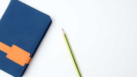 Office desk table keyboard and book note with pencil and post it on white backgroundの写真素材