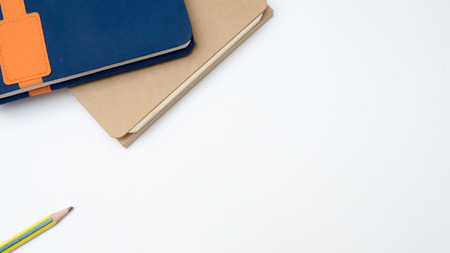 Office desk table keyboard and book note with pencil and post it on white backgroundの写真素材