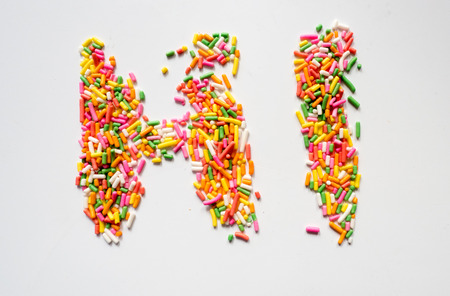 macro of rainbow sprinkles letter hi on white backgroundの写真素材