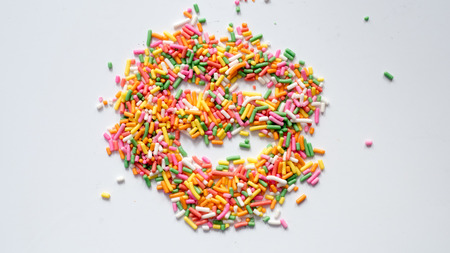 macro of rainbow sprinkles concept smile white backgroundの写真素材