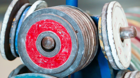 close up Gym equipment with steel plates are coated with colorful rubberの写真素材