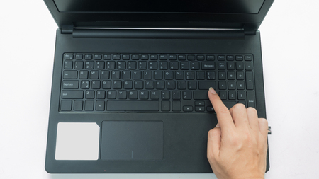 hand on keyboard typing with notebook top view