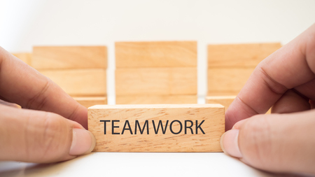wooden block concept team work  on white background with handの写真素材