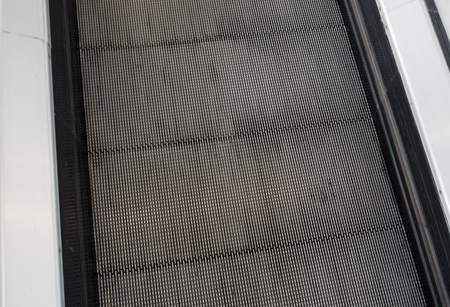 Escalator in metro. Moving down staircase. escalator. electric escalator.Close up to escalators. electric escalator.Close up floor platform  metalの写真素材