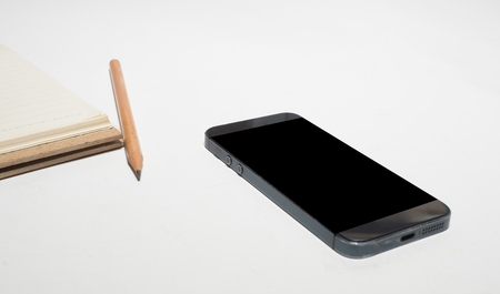 Office desk table with  smart and notebookの写真素材