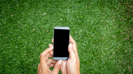 Man holding smart phone nature backgroundの写真素材