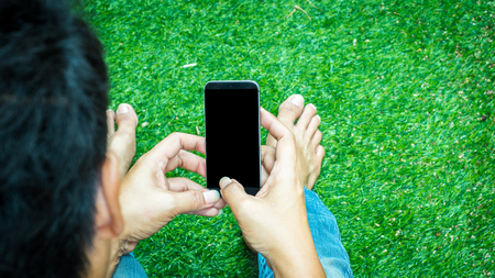 Man holding smart phone nature backgroundの写真素材