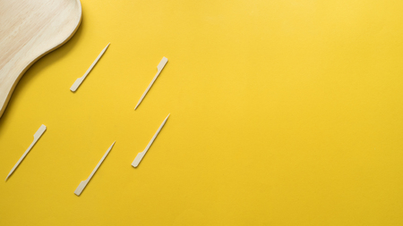 Toothpick and wood plate on yellow backgroundの写真素材