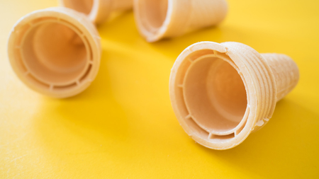 Ice cream cone close up on yellow backgroundの写真素材