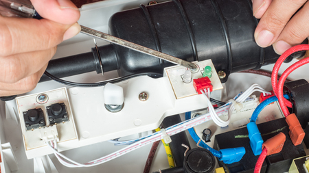 Water heater repair technician service close up hand and screwdriver
